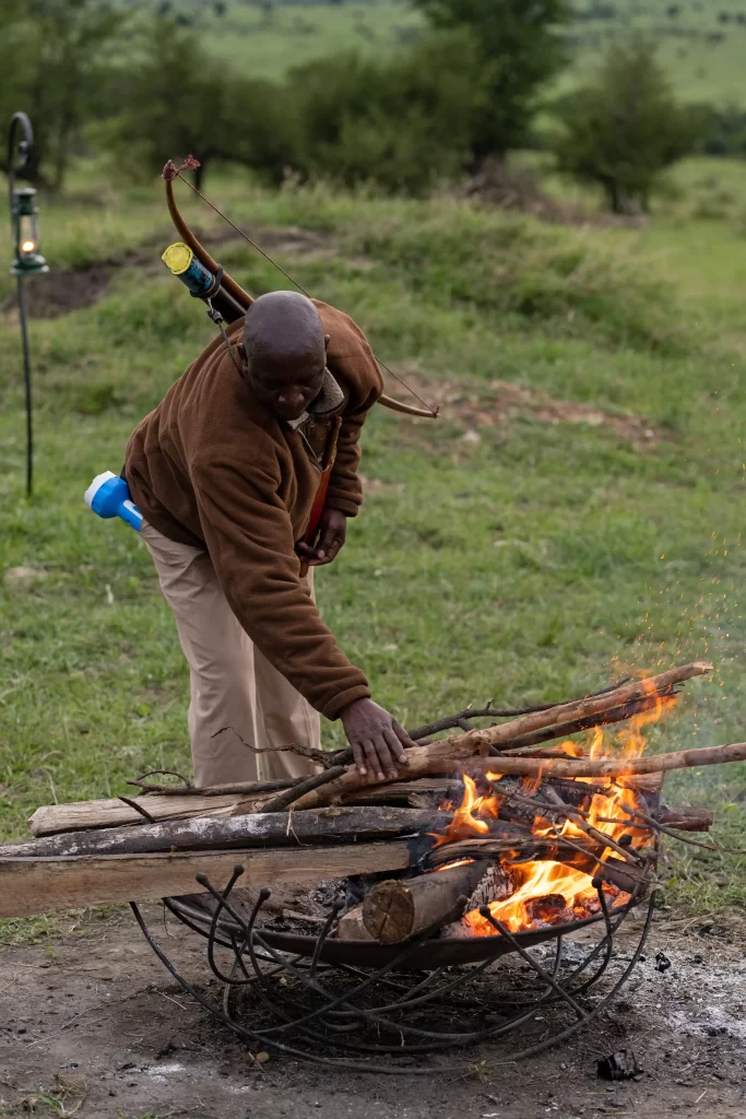 Mara River camp staff setting the guests bonfire - Karibu camps & lodges
